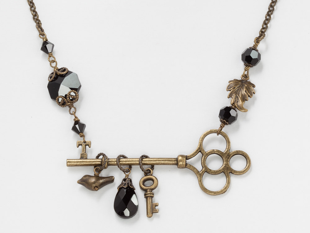 Neo Victorian necklace skeleton key antiqued gold black jet crystal bird charm leaf brass filigree jewelry