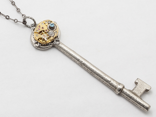 skeleton key gold watch movement silver filigree blue crystal pendant close up by Maria Sparks